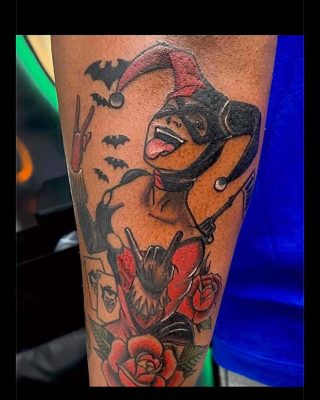 A tattoo depicting a woman holding a bat alongside a beautifully detailed rose.