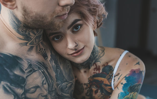 Young tattooed girl hugging her boyfriend