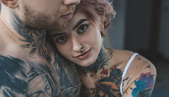 Young tattooed girl hugging her boyfriend